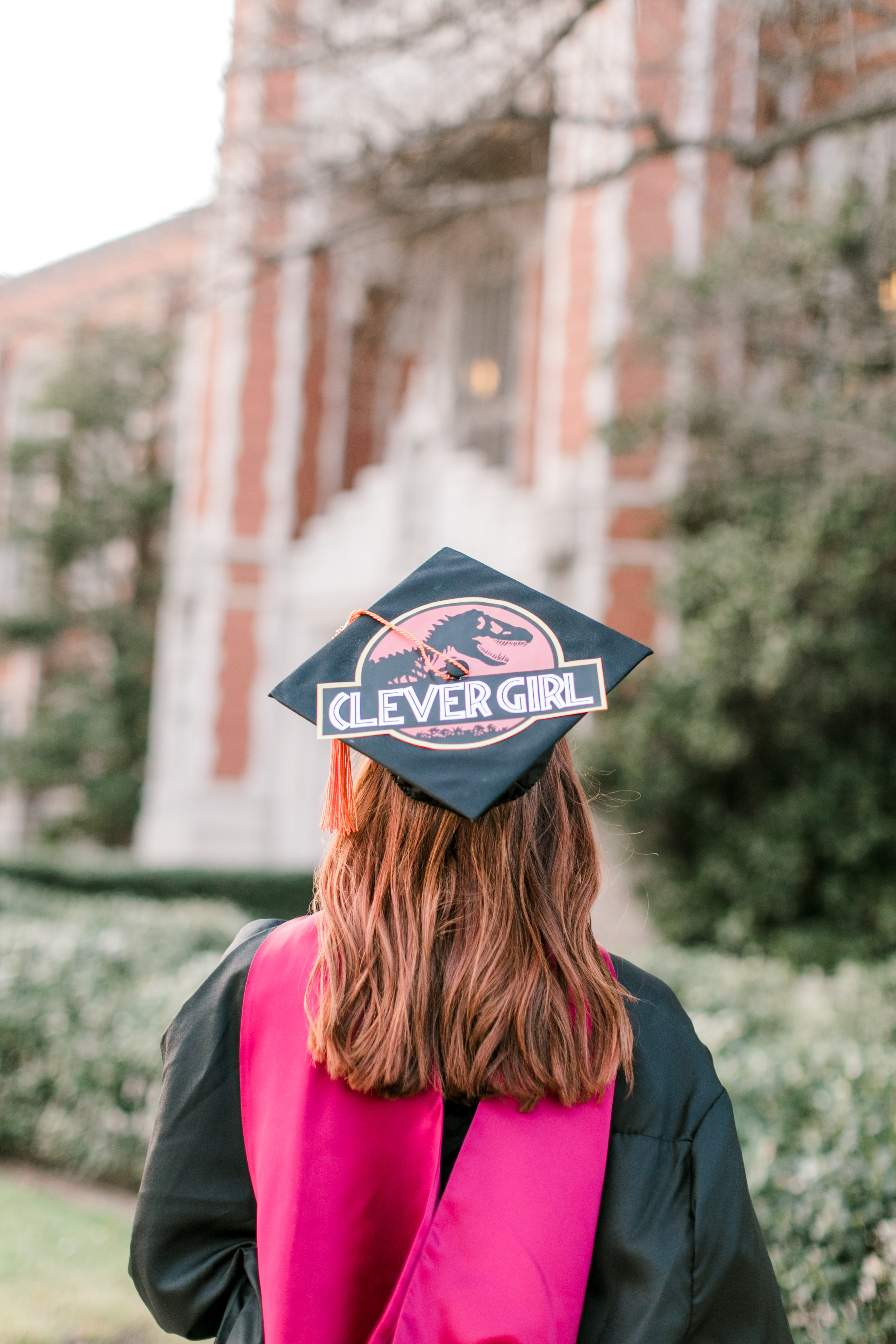ou graduate looks up at bizzell library in decorated graduation cap
