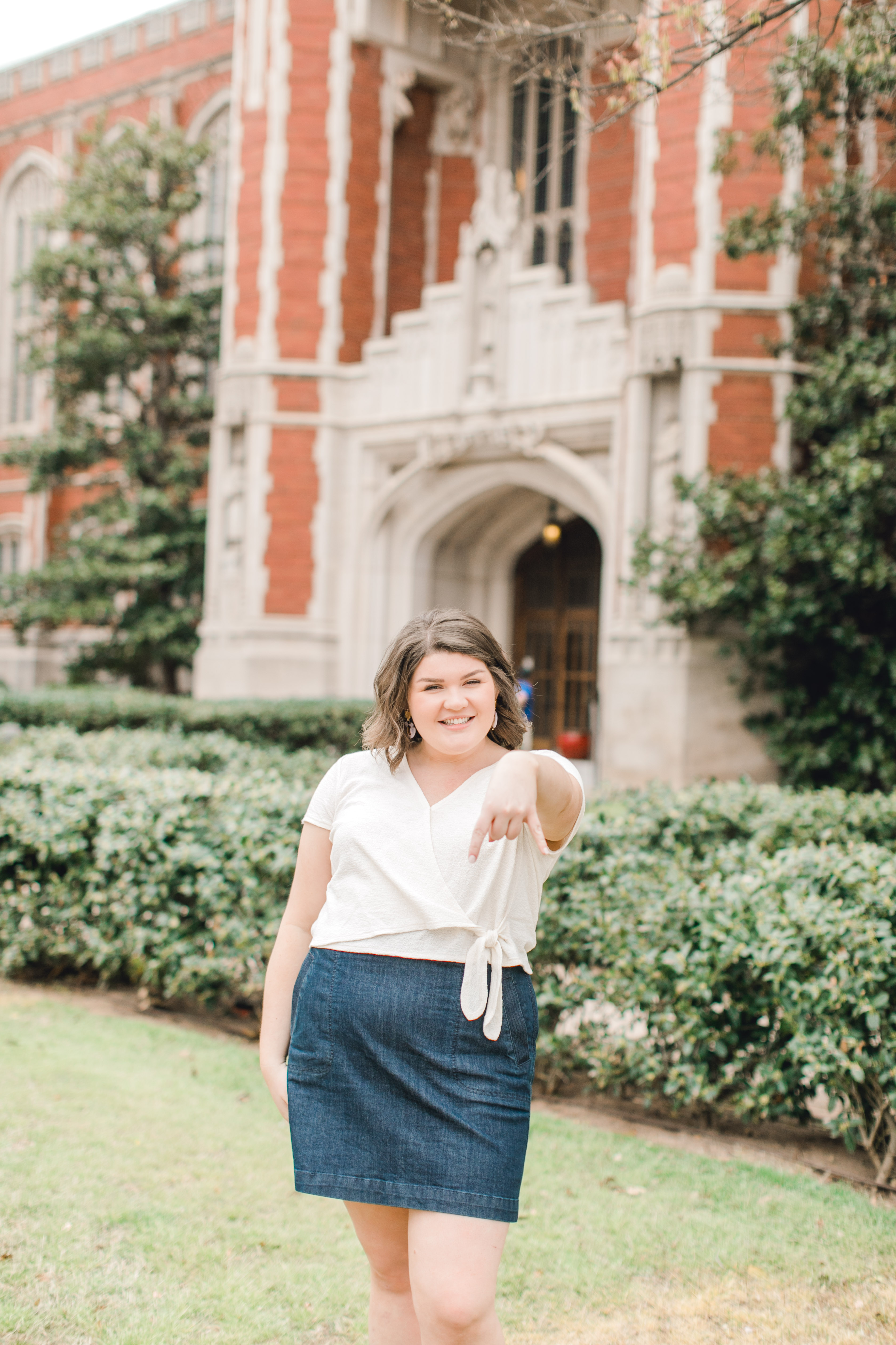 ou senior poses in front of bizzell memorial library with horns down