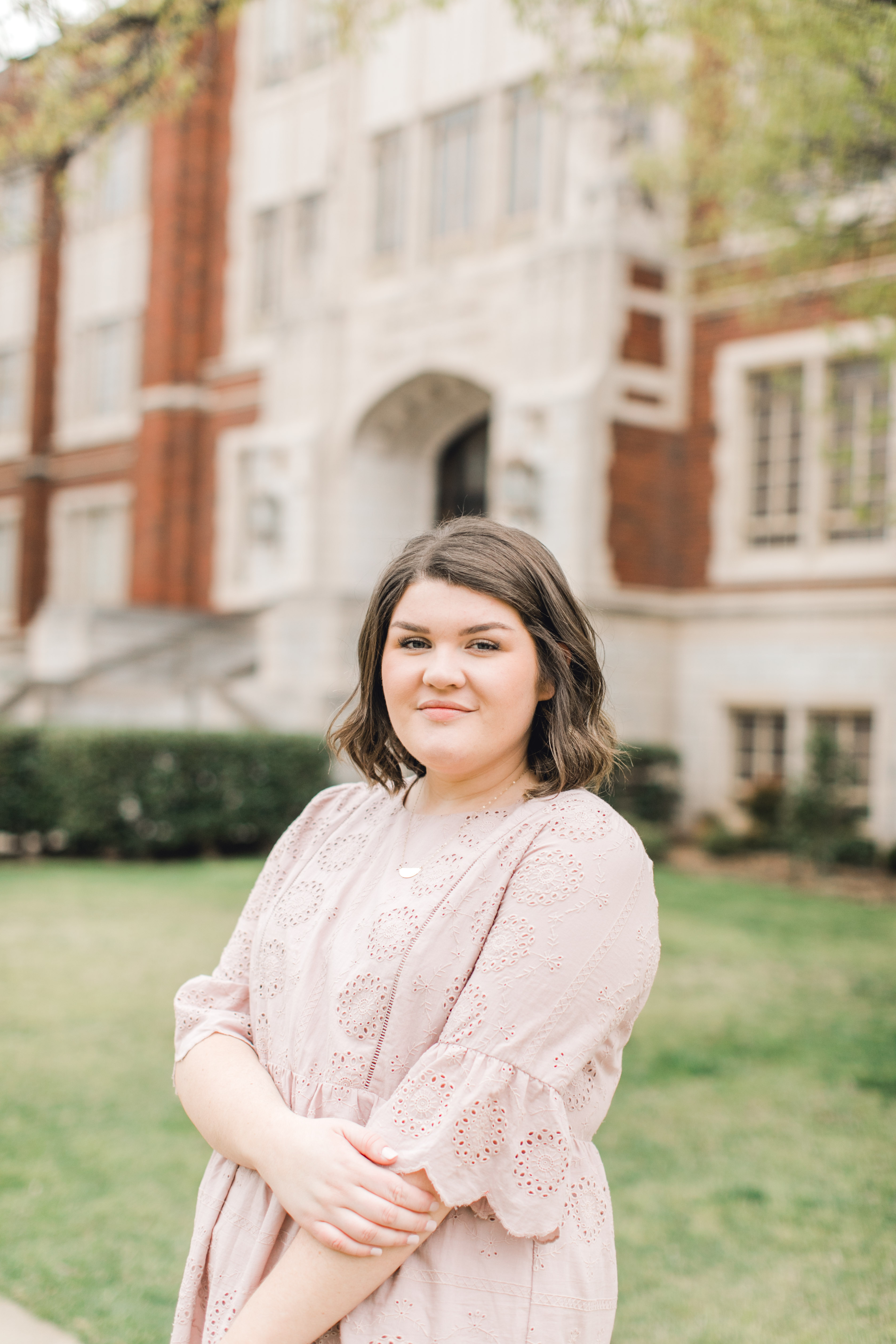 ou senior stands in front of college building for norman oklahoma photographer