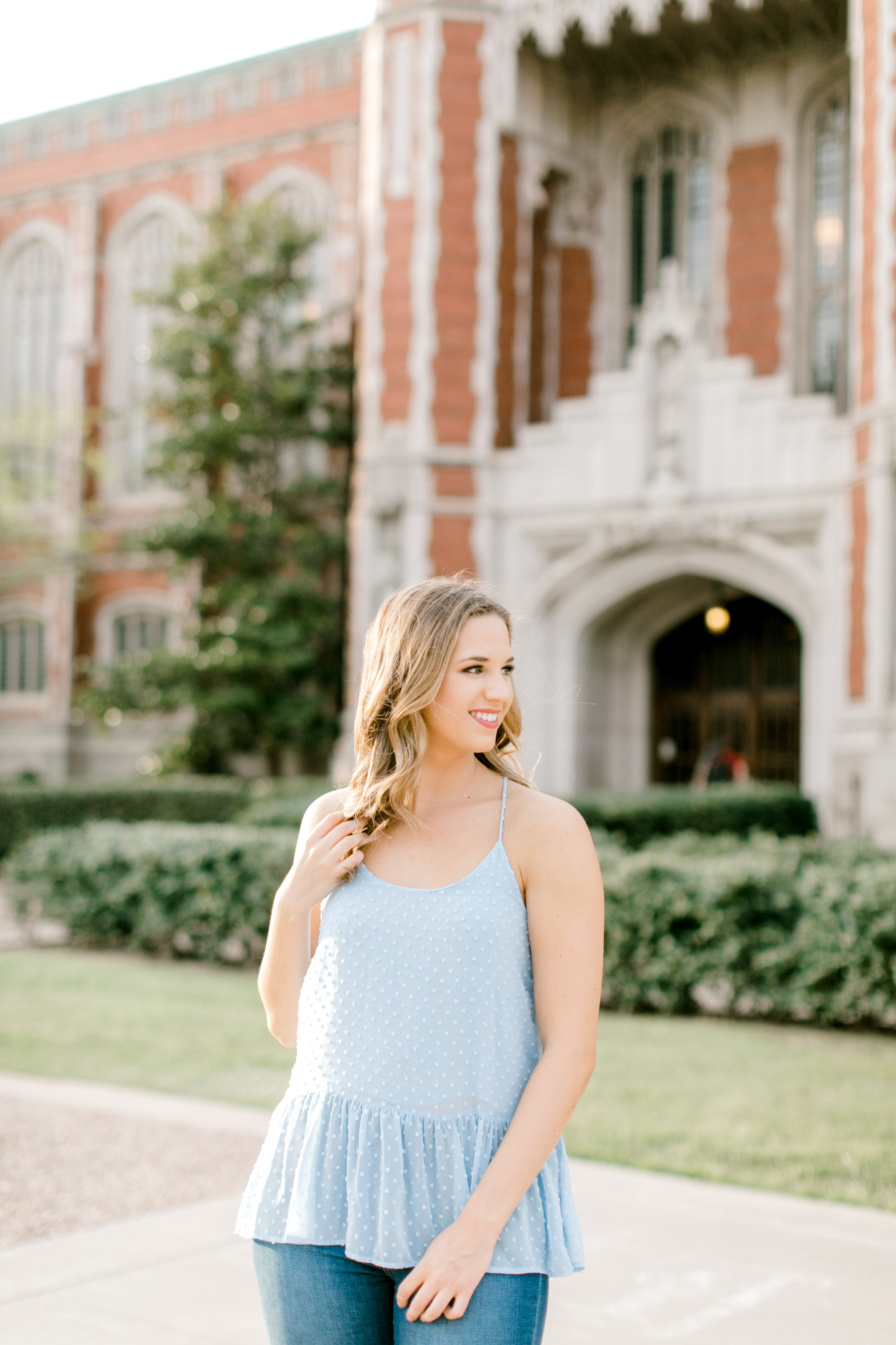 ou senior holds hair in front of bizzell library for norman senior photographer