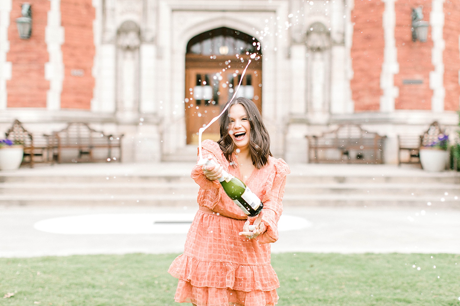 popping champagne for graduation photos at ou