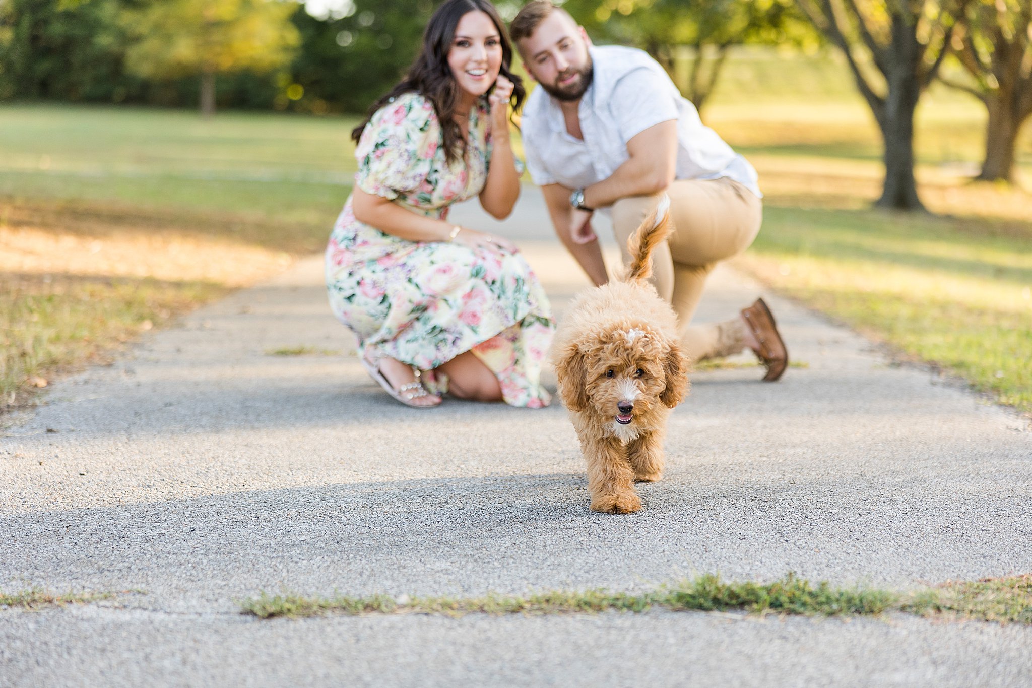 puppy runs towards camera with couple watching behind for bartlesville mini session photographer