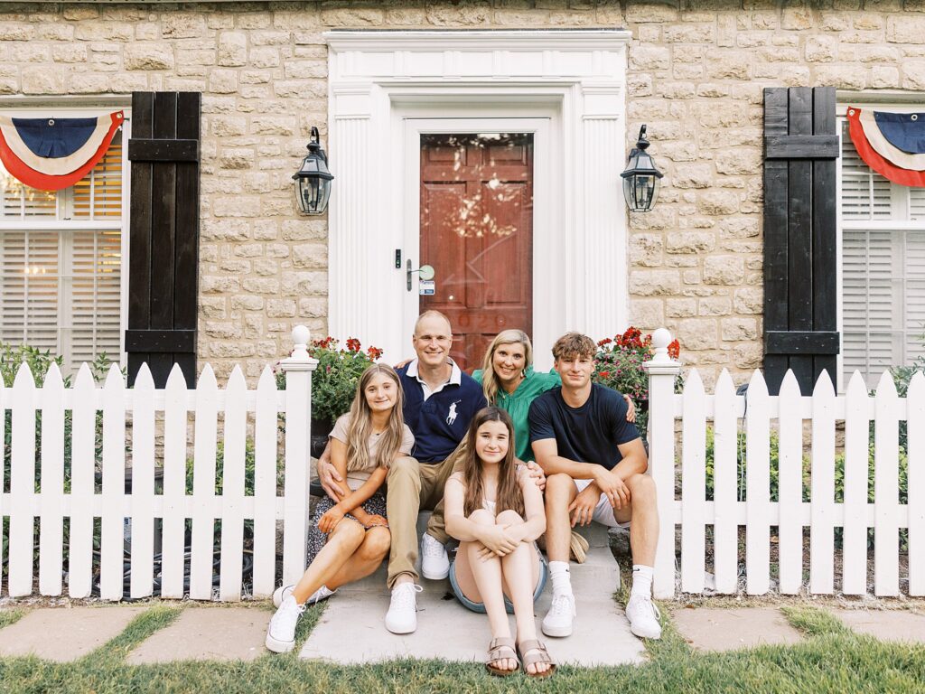 bartlesville family sits on the steps of their front door for a photo