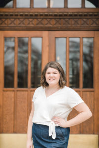 ou senior poses with hand on hip in front of brown collegiate doors