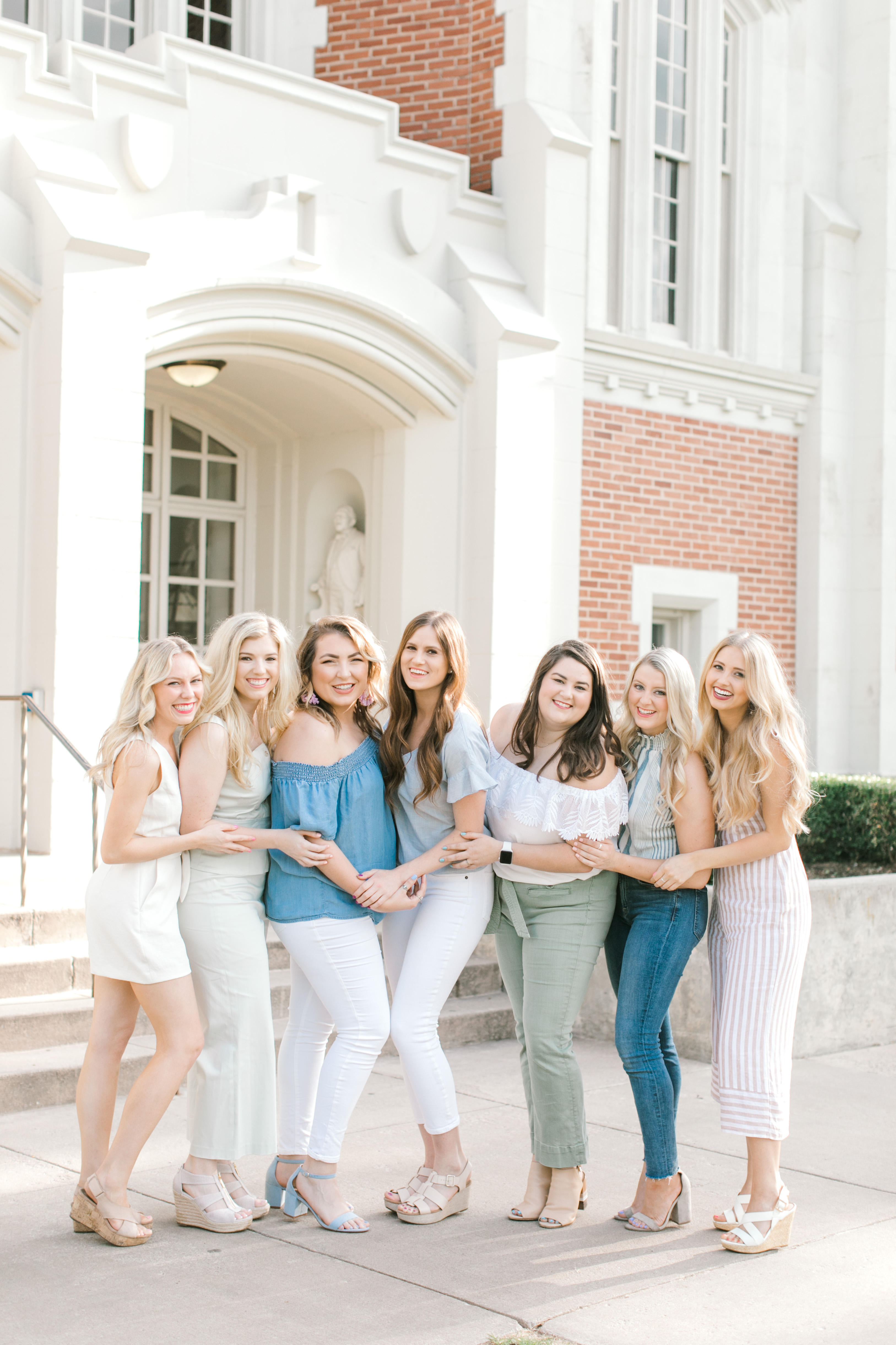 ou sorority senior photos group of girls pose in front of college building