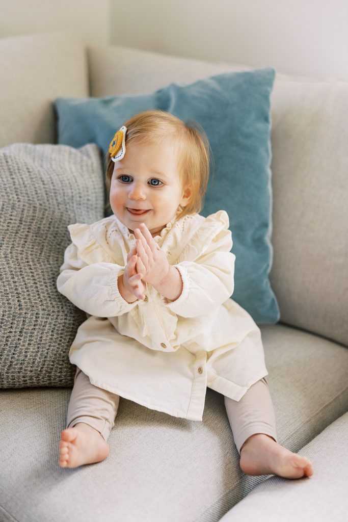 baby girl claps hands in western themed outfit for rodeo birthday party