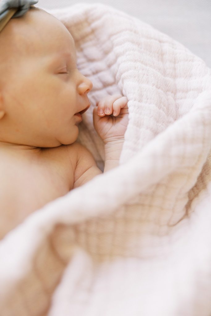 Newborn baby sleeping in pink blanket