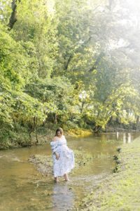 Woman stands in a creek in Bartlesville park