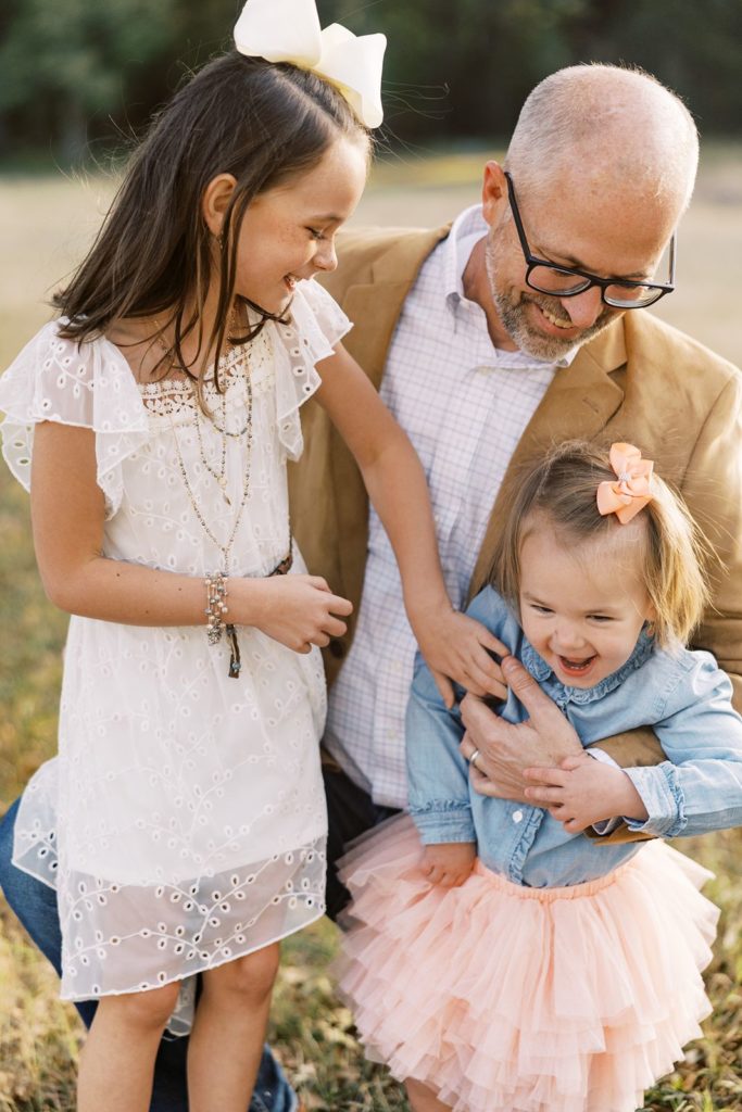 Dad poses with his two daughters during family portraits