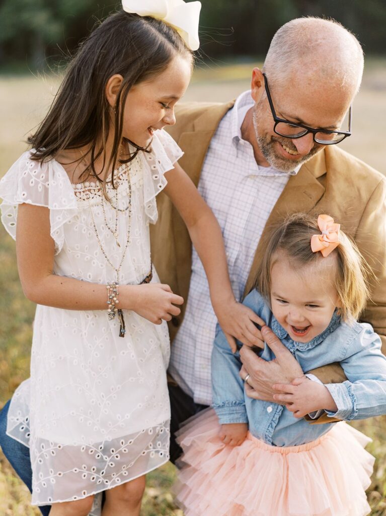 Dad poses with his two daughters during family portraits