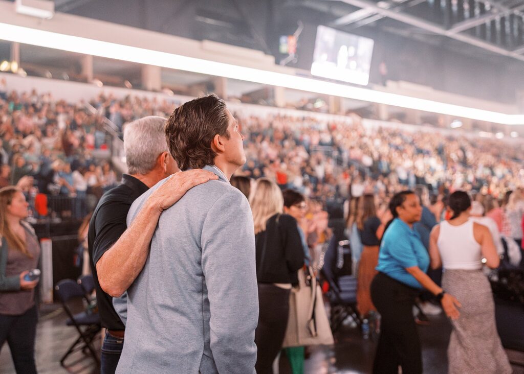 Chief Relatabro looks on as Allie Stuckey takes the stage at the Share the Arrows conference